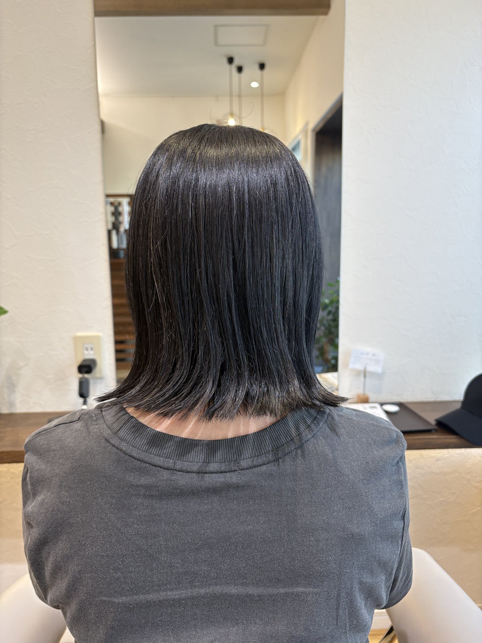 後頭部に丸みを残しつつ毛先を外へ流した後ろ姿|暗髪のツヤが際立つ切りっぱなしミディ、真後ろ