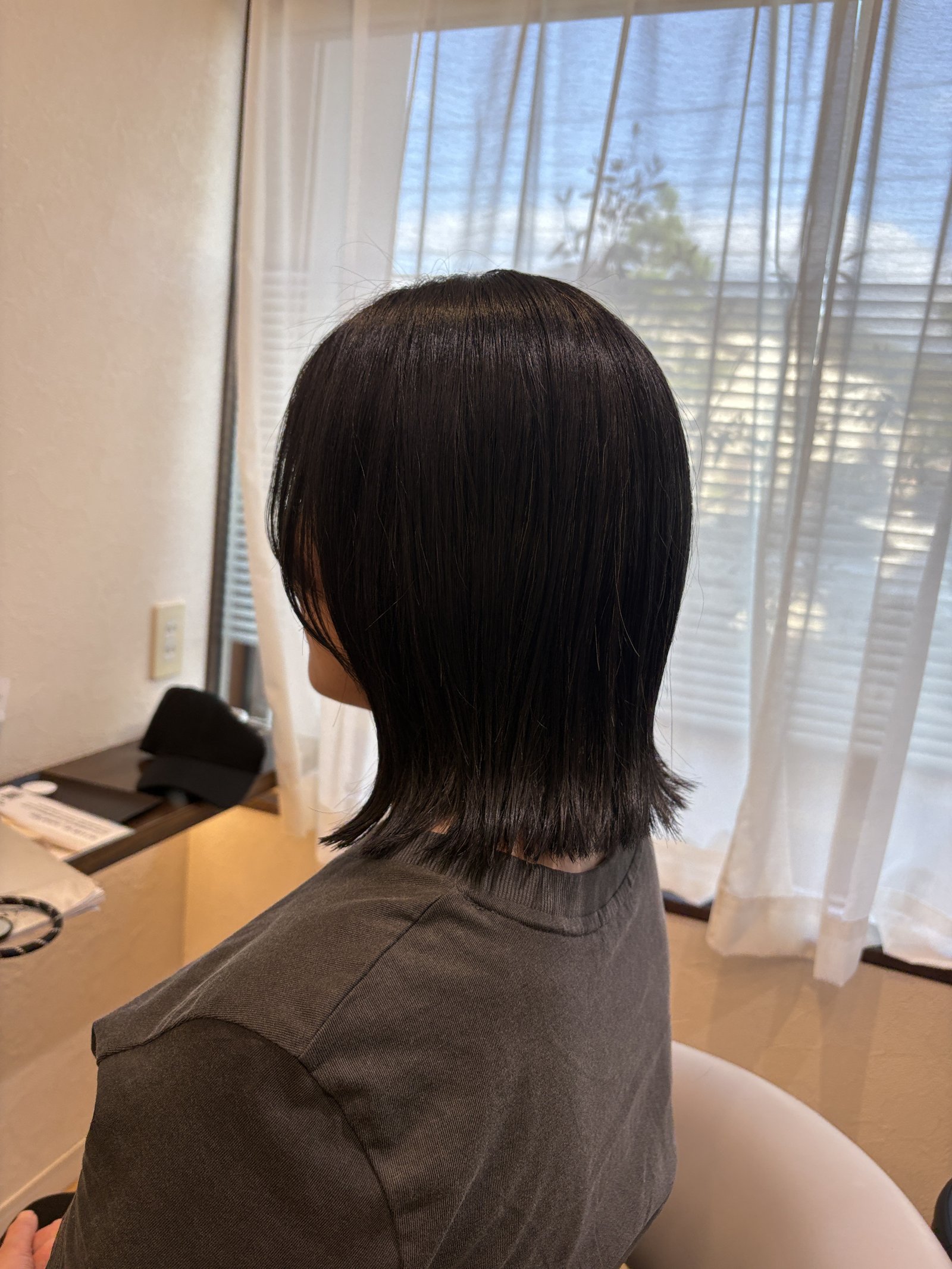 襟足まわりにレイヤーを入れて軽さを出した後ろ姿|毛先が自然に外へ流れるミディアム、斜め後ろ