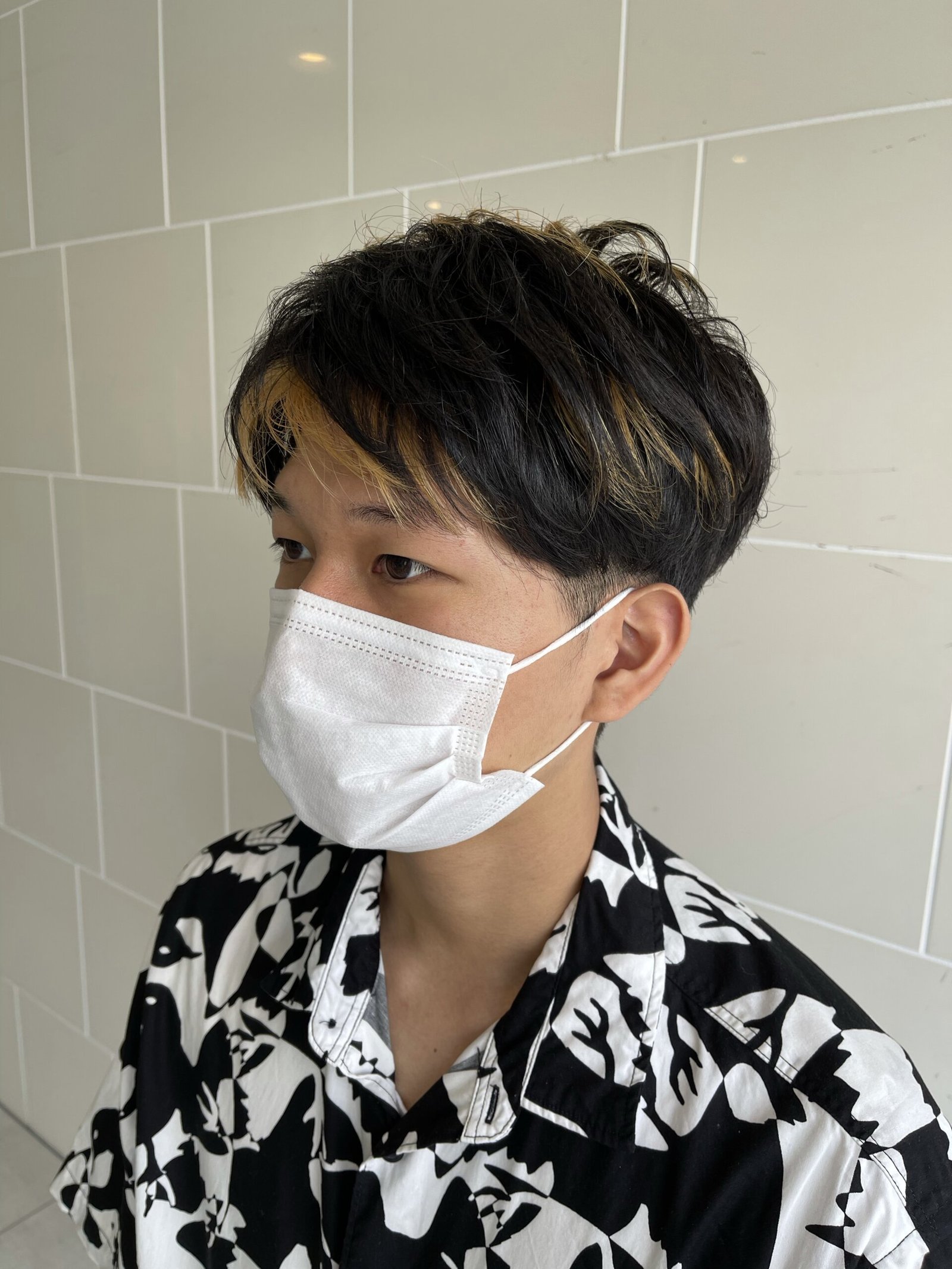 黒髪ベースに金髪の太めメッシュを入れたメンズショート、前髪の内側から金の束がのぞくデザイン