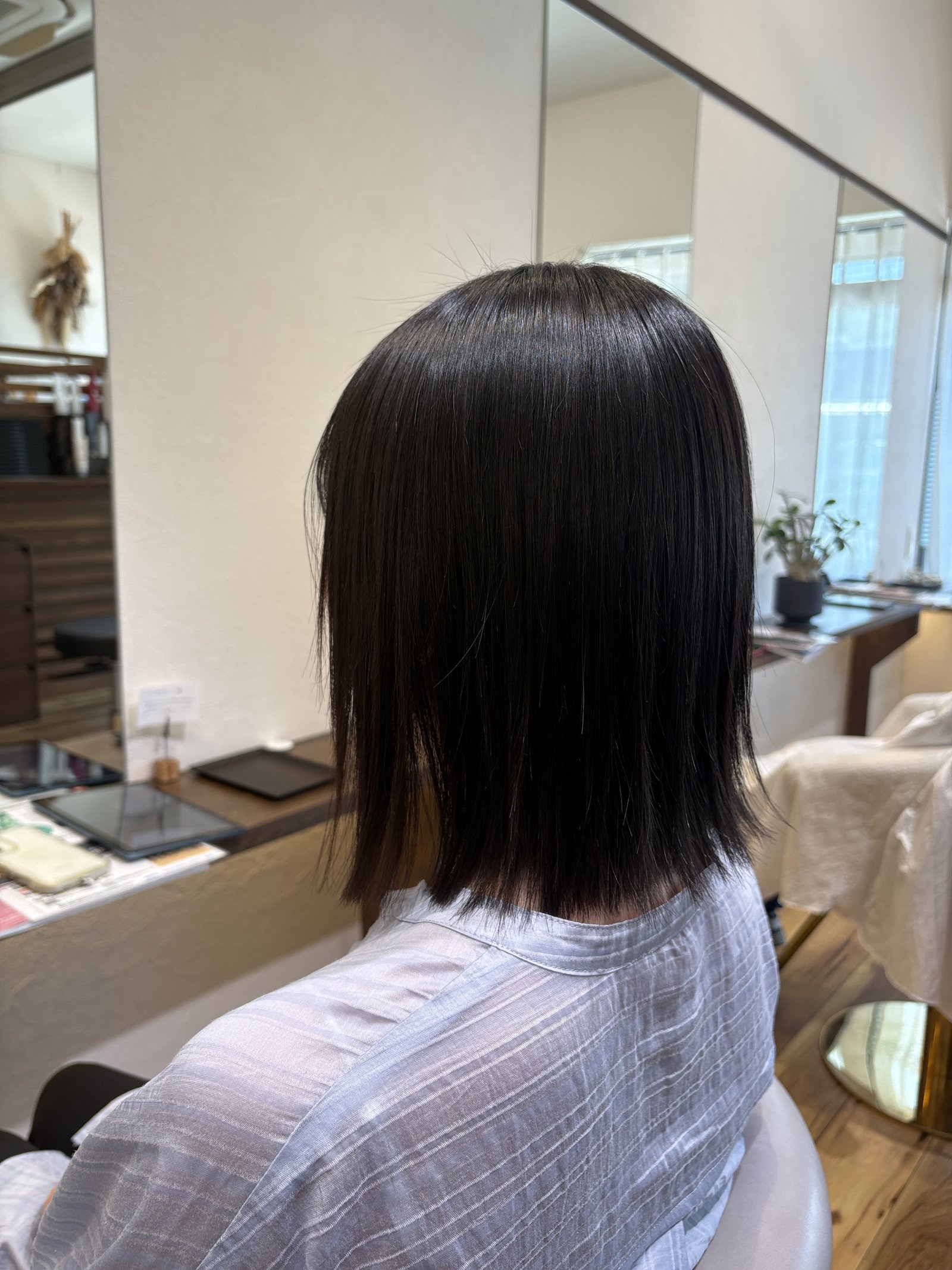 厚みを残したワンレングスライン|斜め後ろから見た暗髪ミディアムのシルエット
