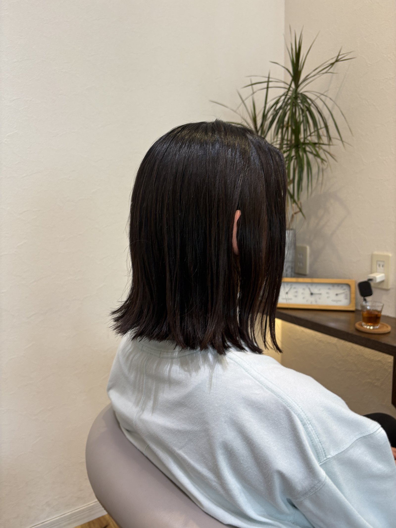 光をまっすぐ返す暗髪ストレート|肩ラインで切り揃えた切りっぱなしミディアム、斜め横