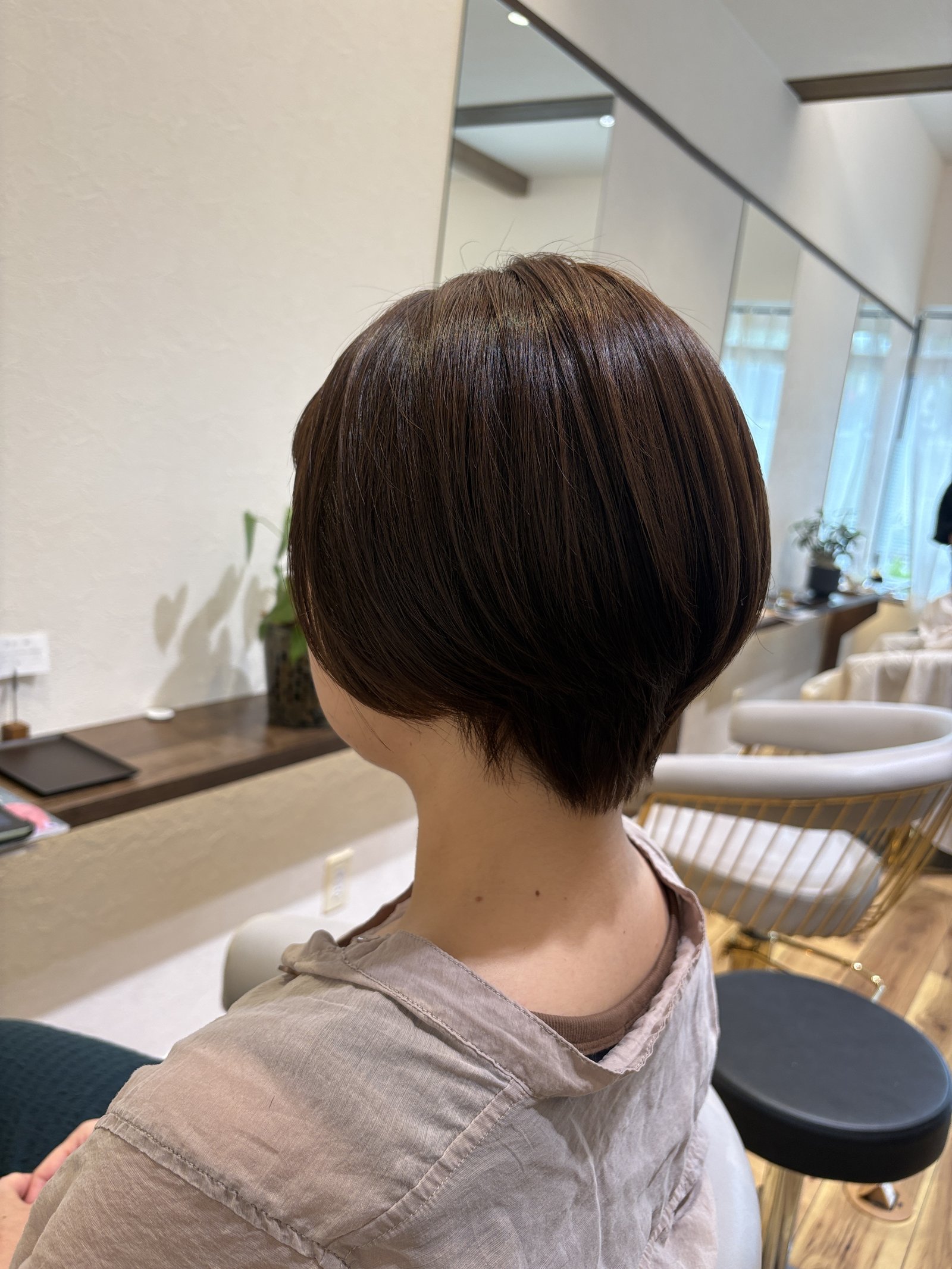 やわらかなナチュラルブラウンをまとった丸みショートボブ|首もとかろやかな大人ショート、斜め横