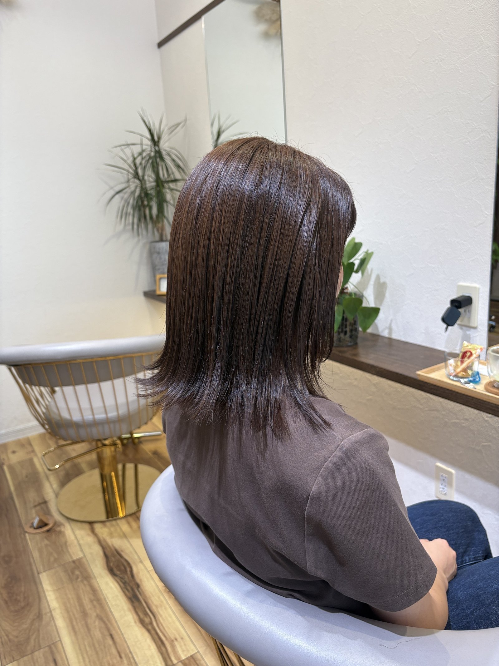 毛先に軽いレイヤーを入れて動きを出したセミロングのシルエット、斜め後ろ