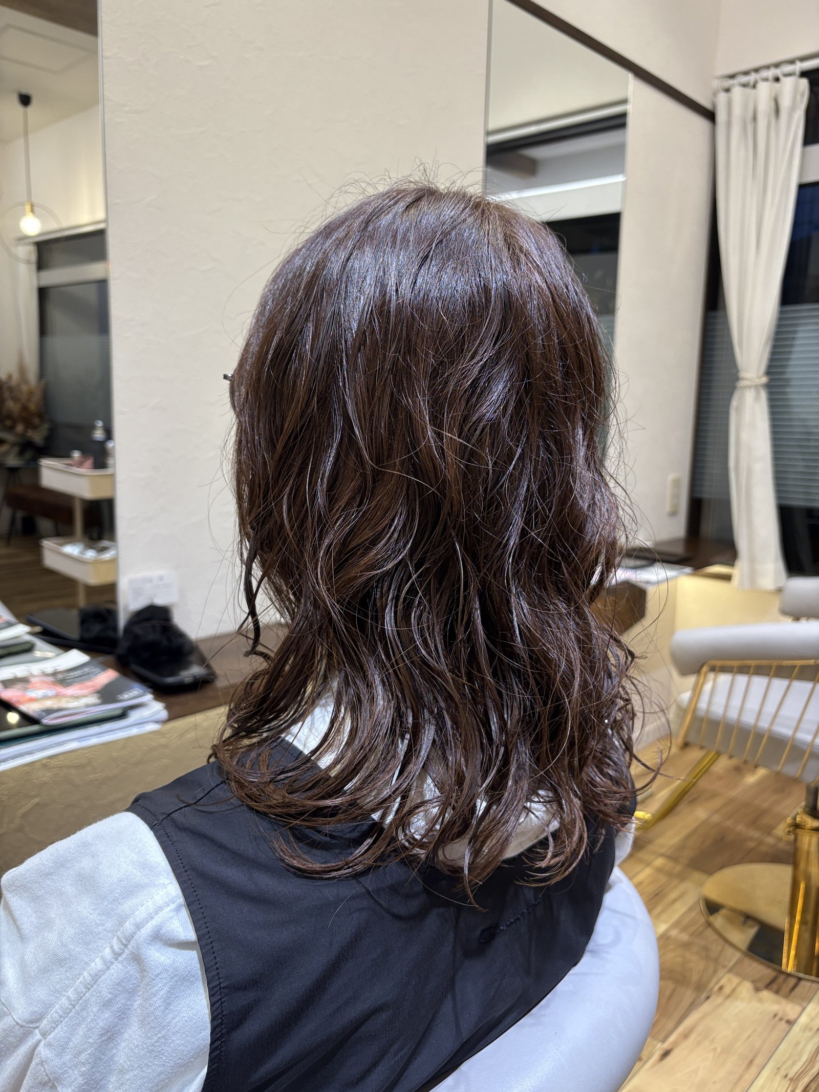 レイヤーで軽さを出した毛先のカール感|ふんわり空気を含む大人セミロング、斜め後ろ
