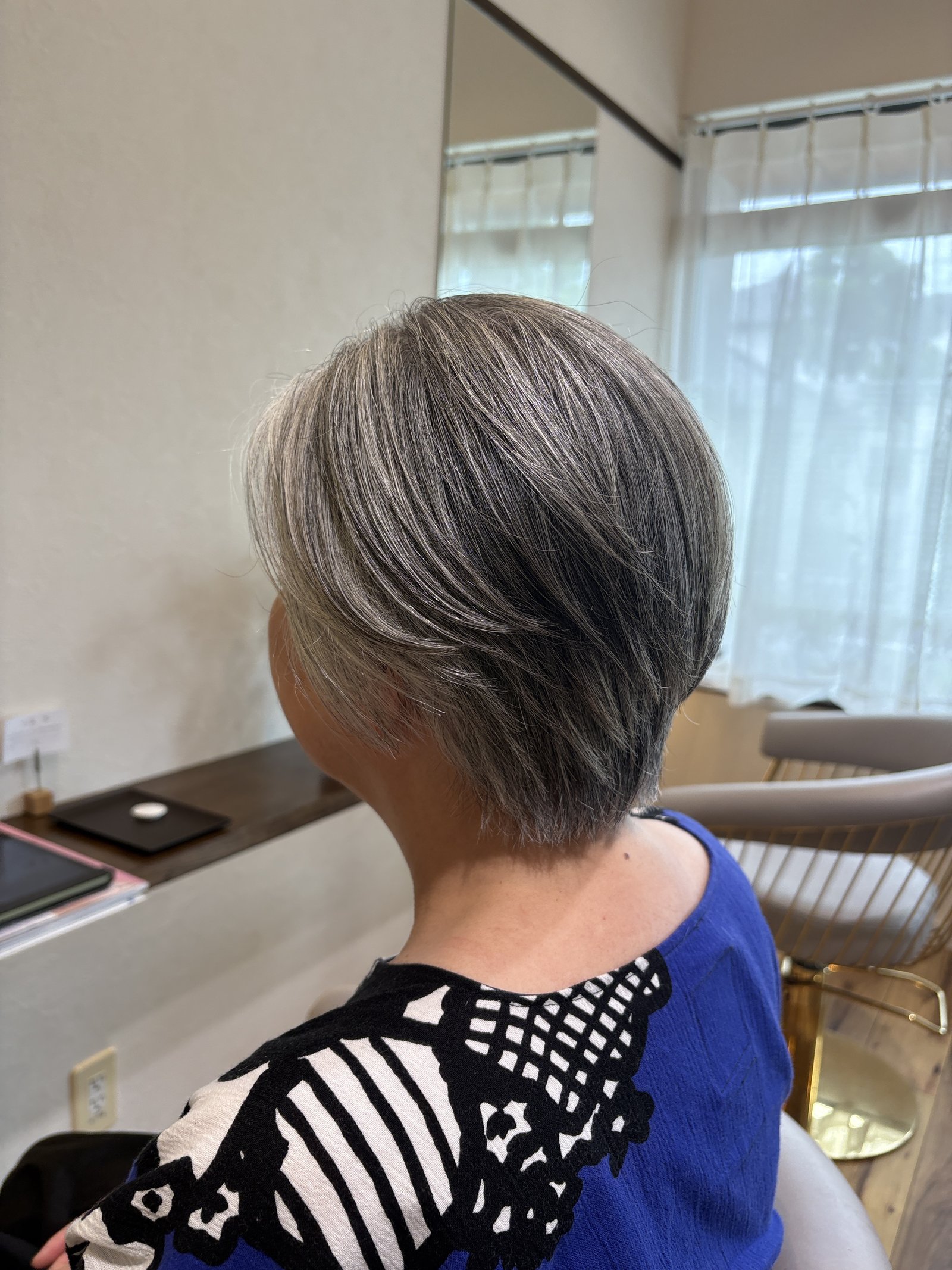 後頭部の丸みから襟足へのすっきりライン｜レイヤーの毛流れが立体感を生む大人ショート、斜め後ろ