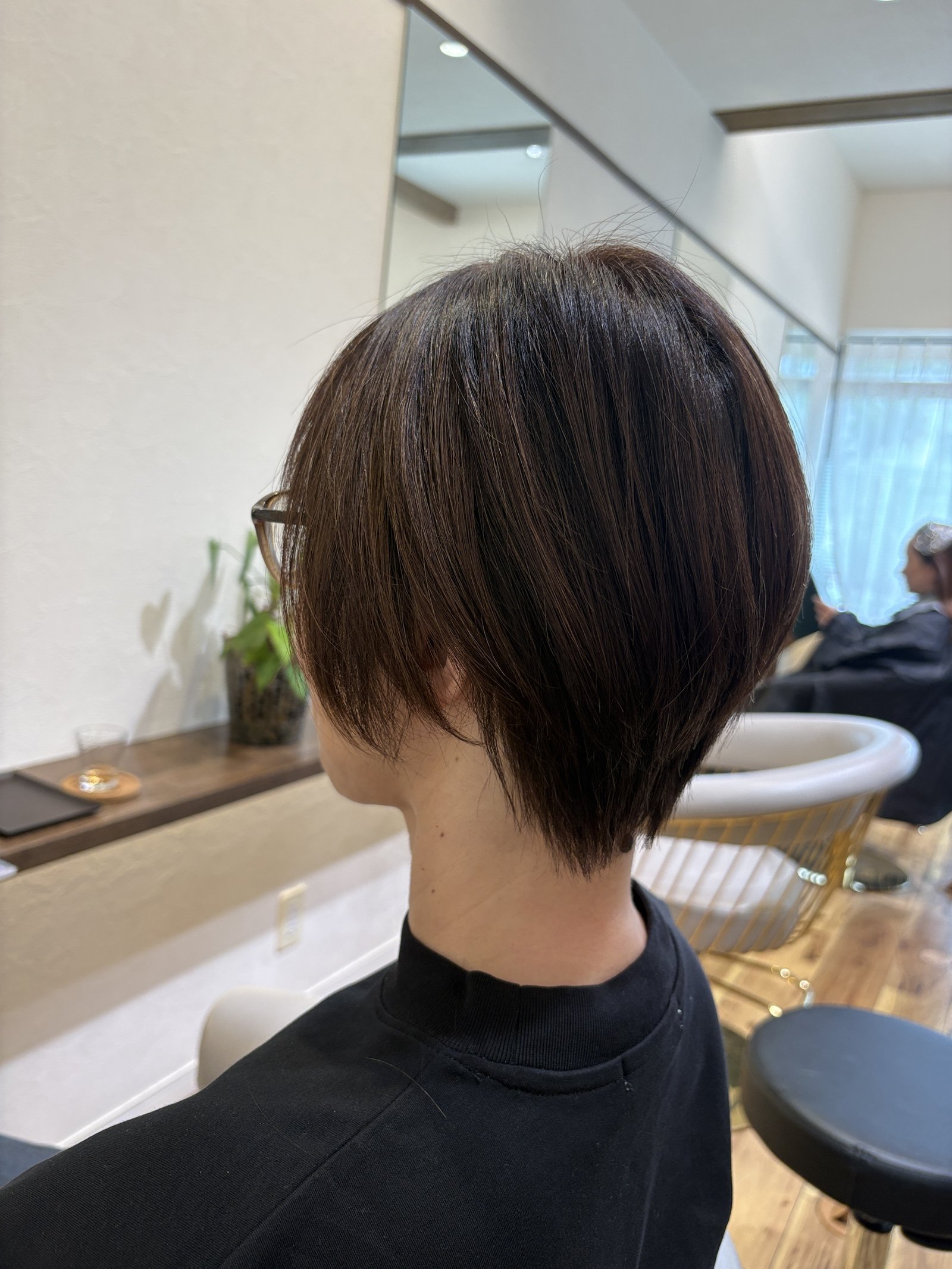 表面のレイヤーとハイライトが重なって立体感に|襟足すっきりの大人ショート、斜め後ろ