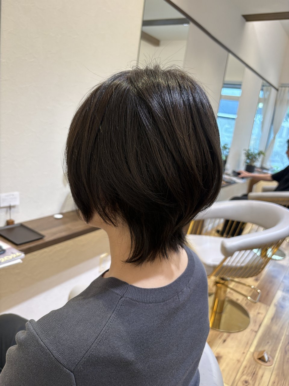 襟足の外ハネがくびれを強調|レイヤーの動きが軽やかな暗髪ショート、斜め後ろ