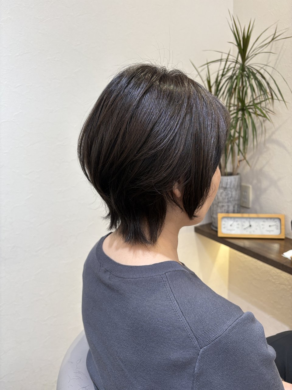 暗髪に映えるくびれシルエット|後頭部の丸みから襟足の抜け感へつながる大人のくびれショート、斜め横