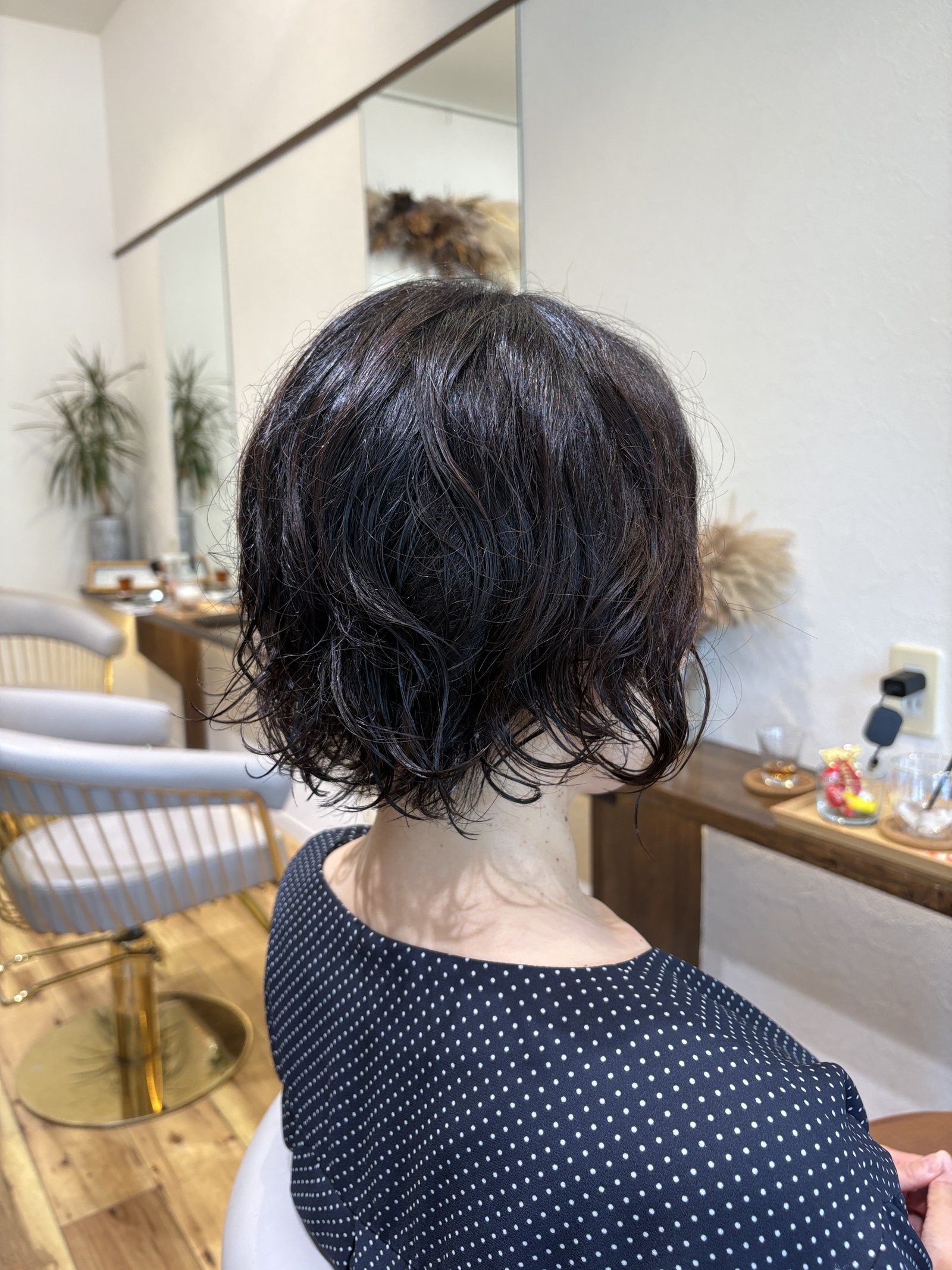 首元すっきりの大人ウェーブボブ|中間〜毛先のしっかりめのウェーブと、首に沿う短めの襟足を斜め後ろから