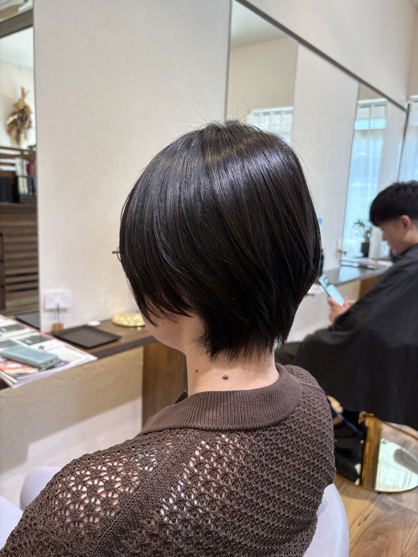 表面のレイヤーで毛先に動き|耳が出る長さのコンパクトショートを反対側の斜め後ろから