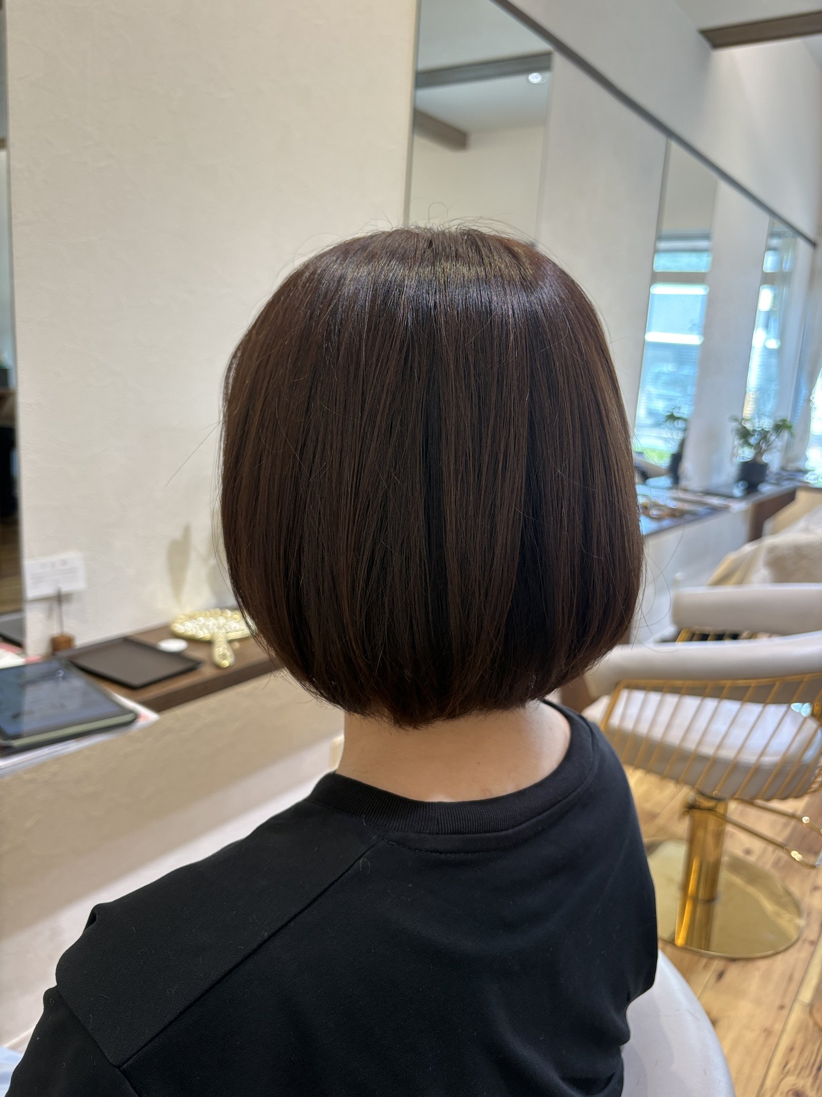 ショコラベージュの重めグラデーションボブ＝あご下ラインで重みを残し、後頭部に柔らかな丸みをつくった大人ボブを斜め横から