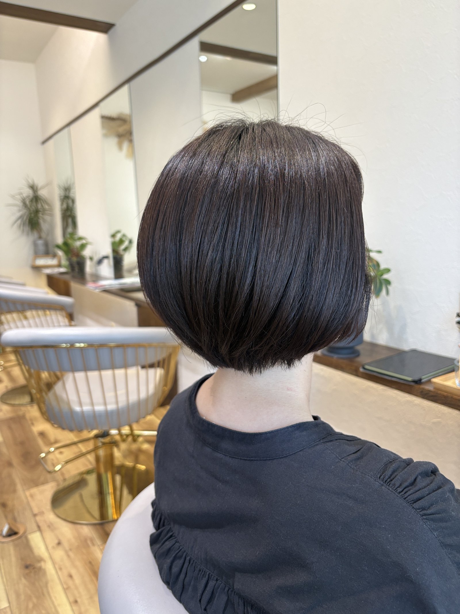 ナチュラルブラウンの丸みショートボブ=ツヤのある自然なブラウンとなめらかな内巻きラインを斜め横から