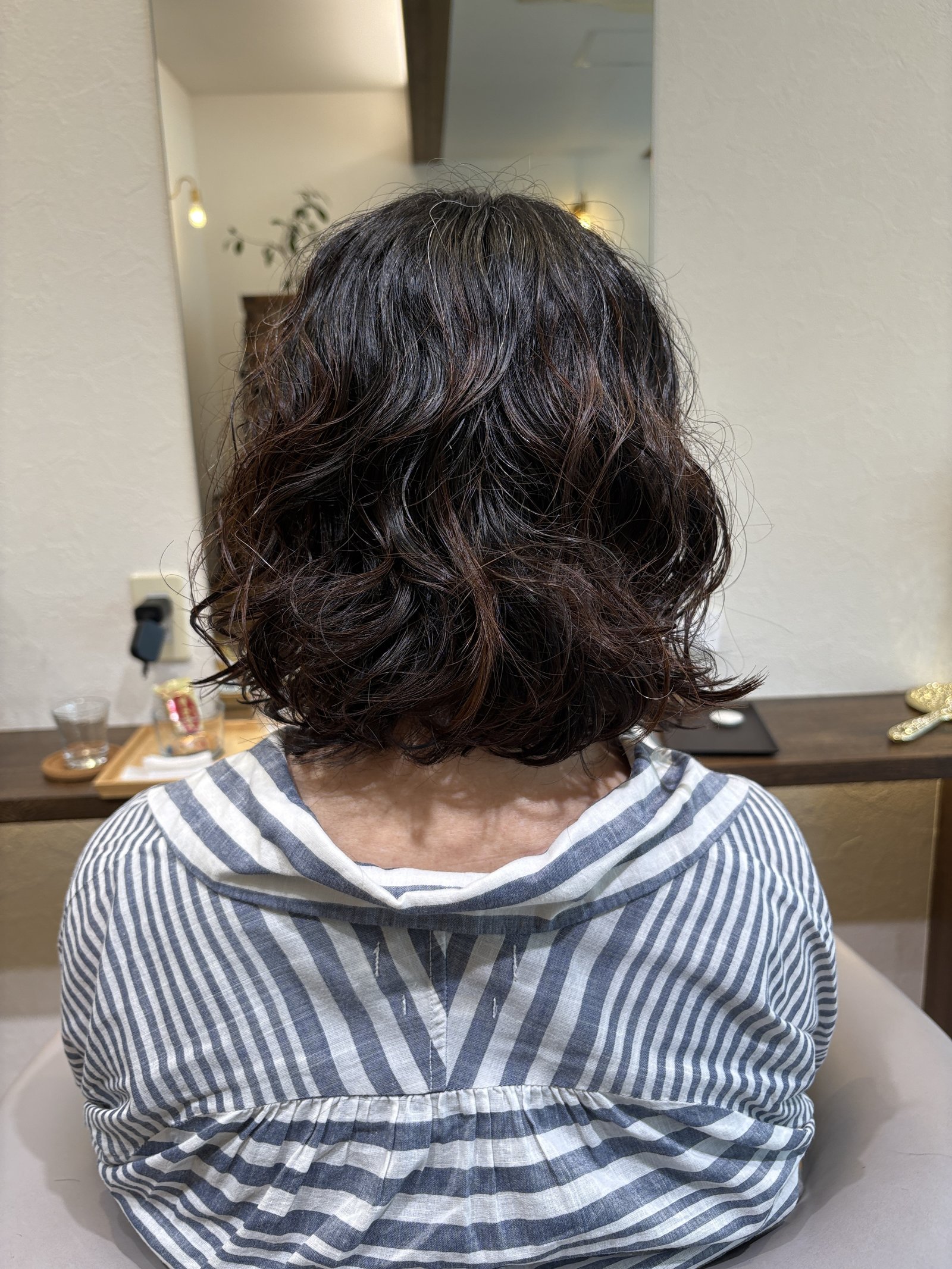 真後ろから見た根元ウェーブの肩ラインボブ=ふんわりしたシルエットと、肩で柔らかく動く毛先