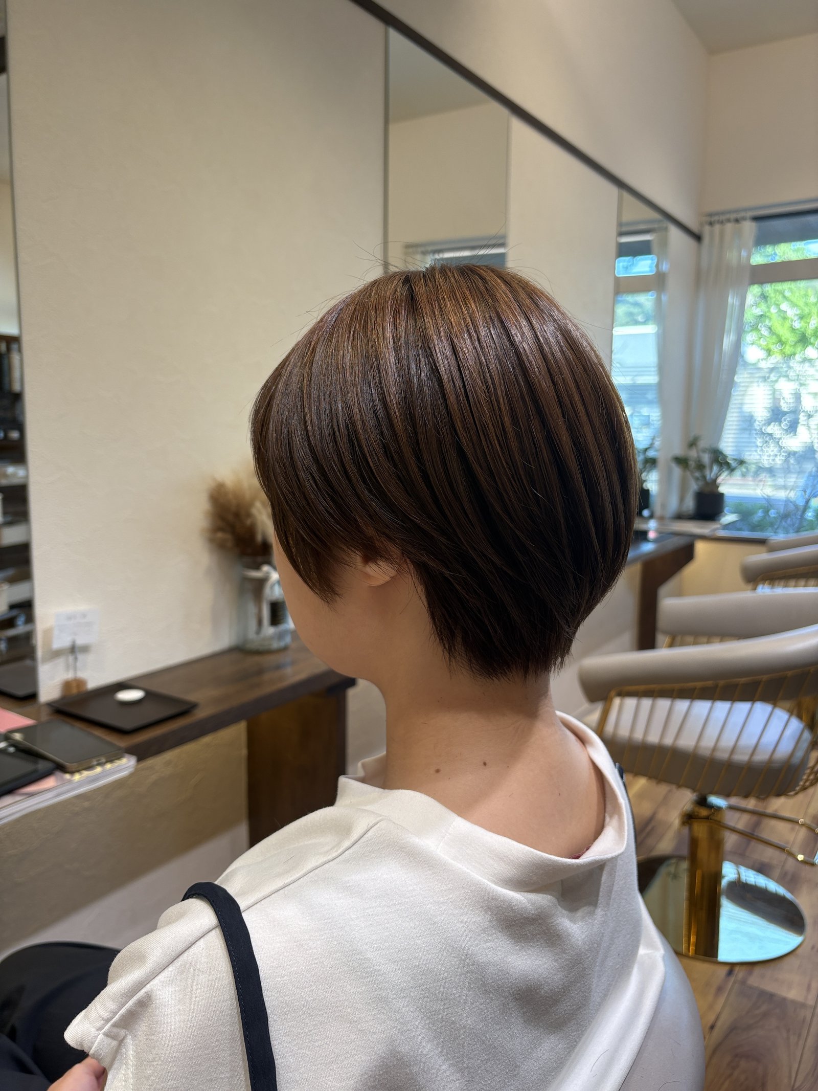 明るめベージュの大人の丸みショート|後頭部の丸みと、耳まわりから首すじへのつながり、左からの斜め後ろ