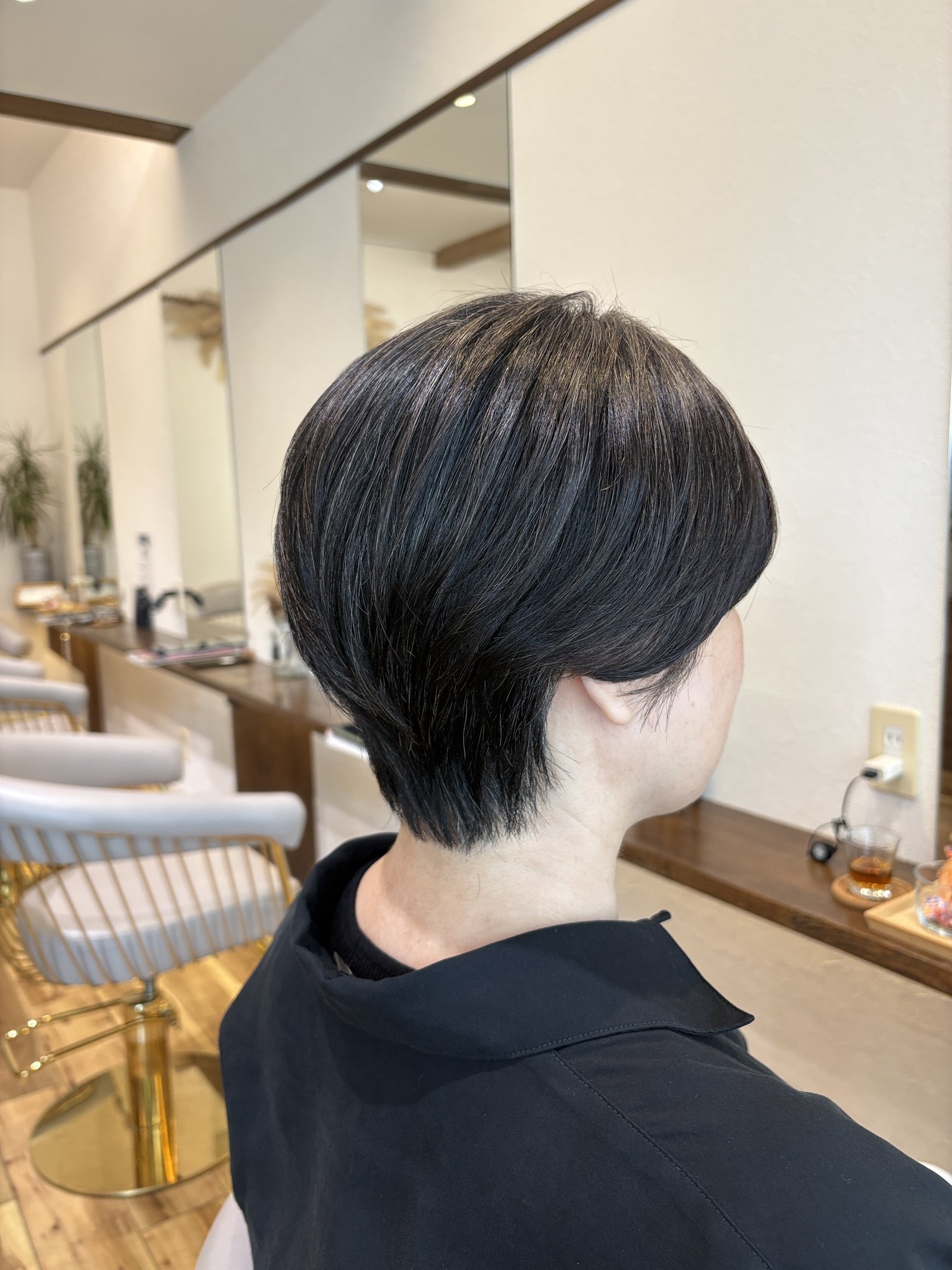 大人のハンサムショート｜丸みを残した後頭部と、えり足へ向かって細く締まるシルエット、右からの斜め後ろ