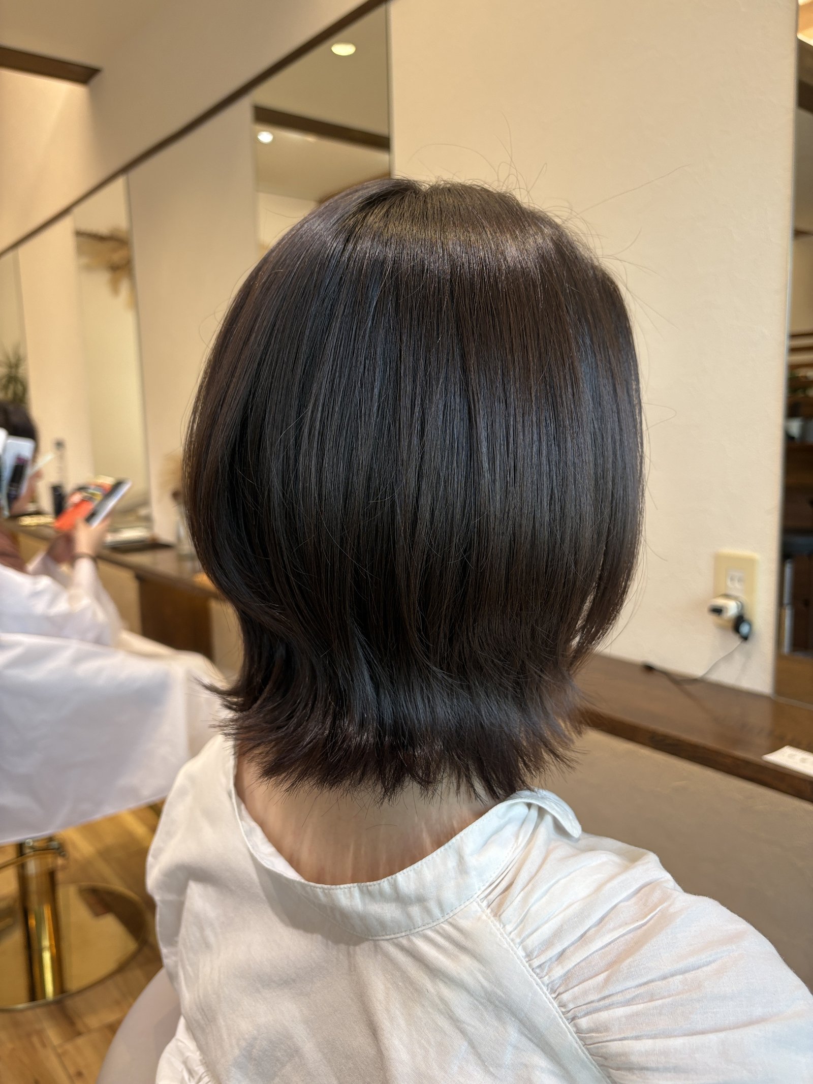 反対側から見たくびれと外ハネ|首もとのレイヤーで軽さを出したショコラブラウンのミディアムボブ