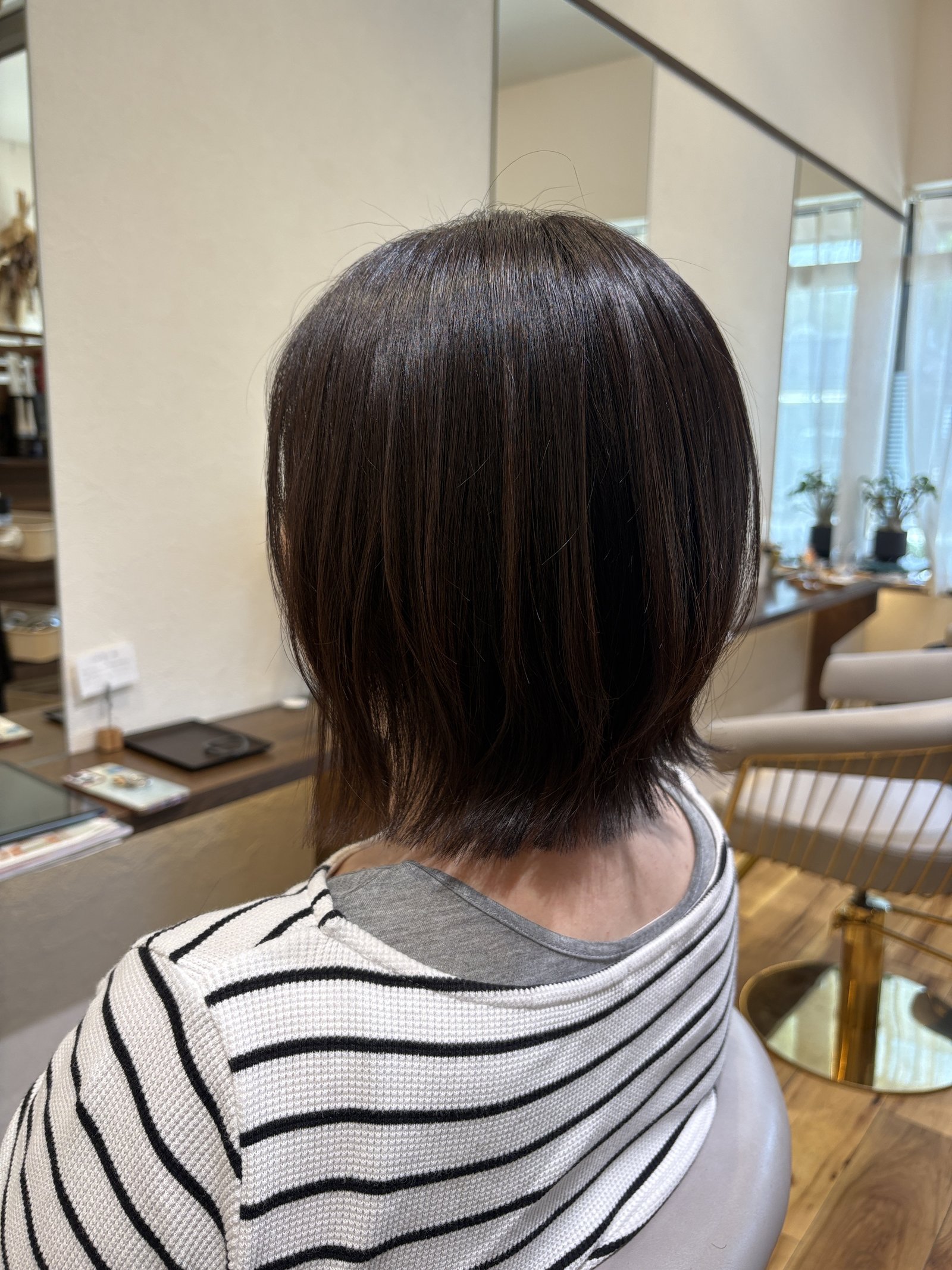 ショコラブラウンの大人レイヤーボブ|毛先の段が重なって軽く動き、表面はなめらかなツヤ・右からの斜め後ろ