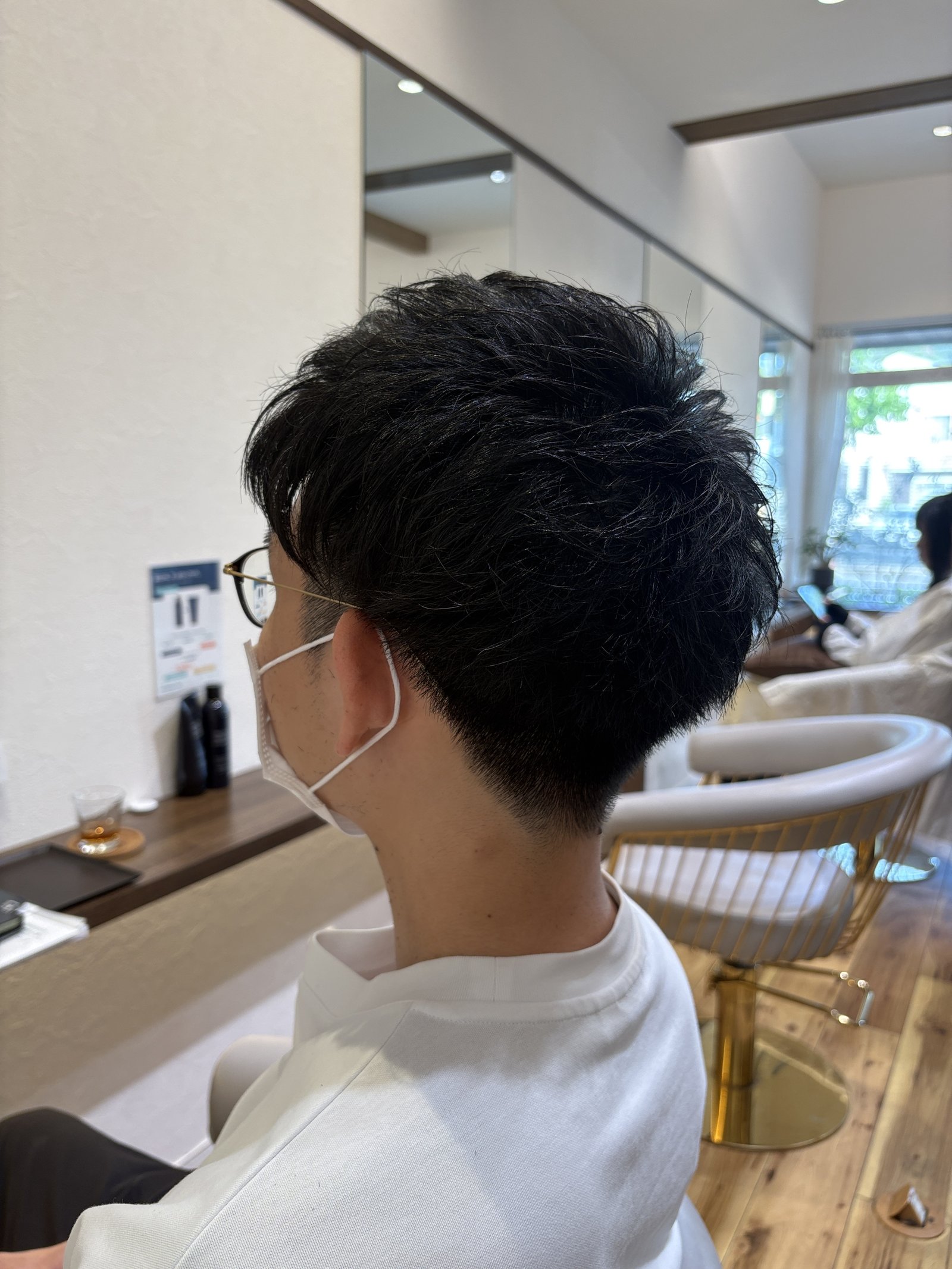 ツーブロック×えり足グラデーションのメンズショート|メガネのつるまわりの短いサイドから、首もとへなだらかにつながる刈り上げを反対側の斜め後ろから