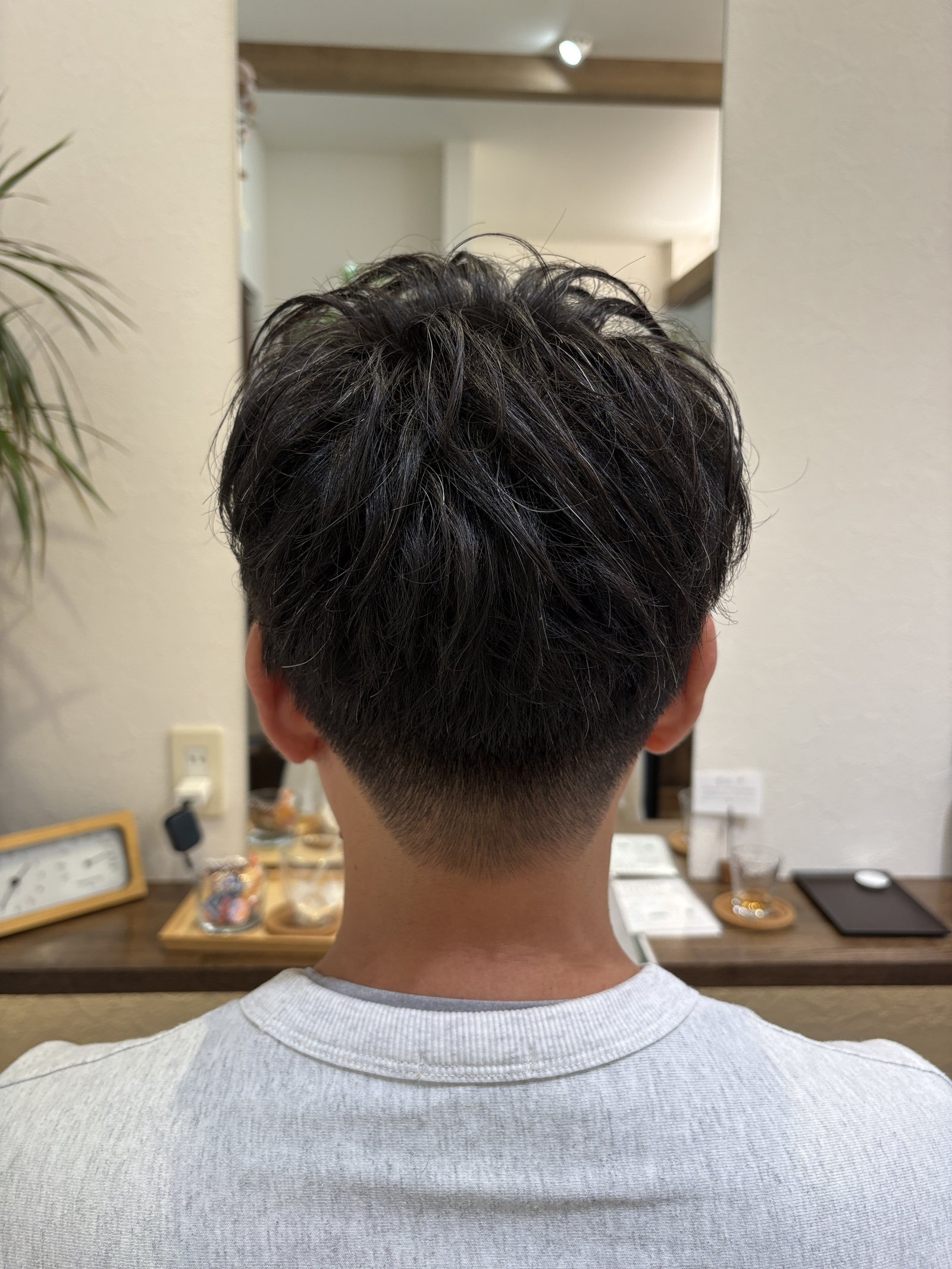 ゆるパーマのメンズツーブロック|後頭部に広がるトップの動きと、すっきり刈り上げたえり足を真後ろから