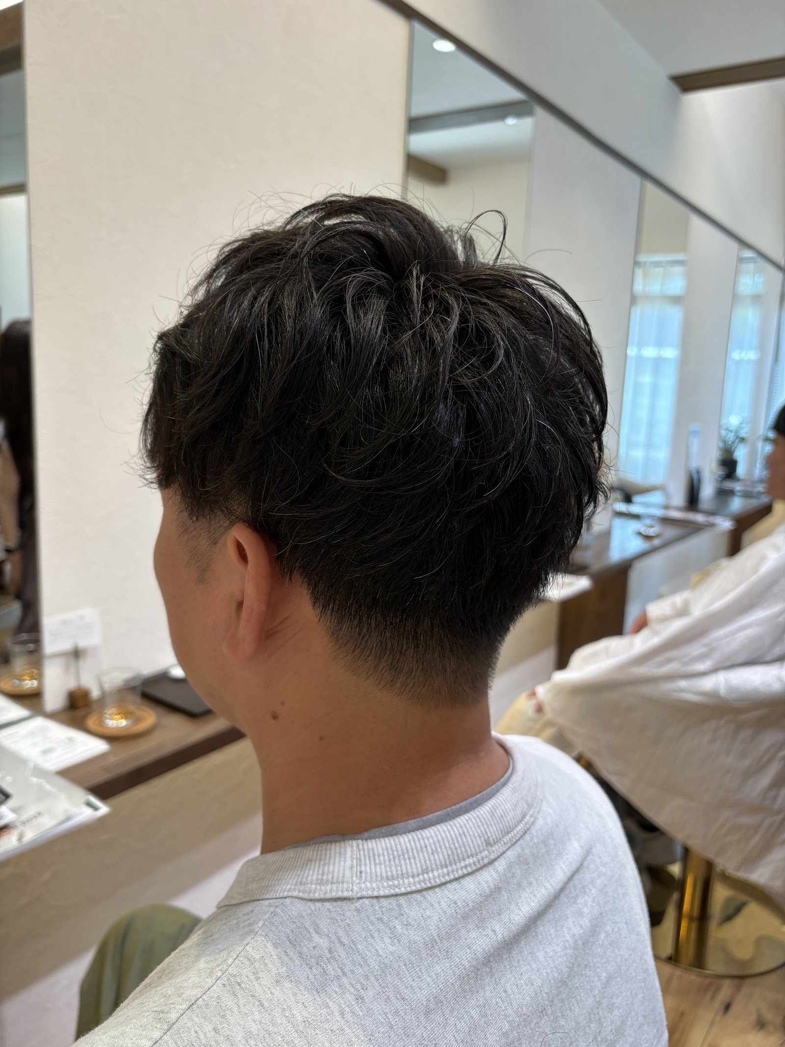 ゆるパーマのメンズツーブロック|長さを残したトップのゆるい動きと、刈り上げで整えた耳まわりを反対側の斜め後ろから