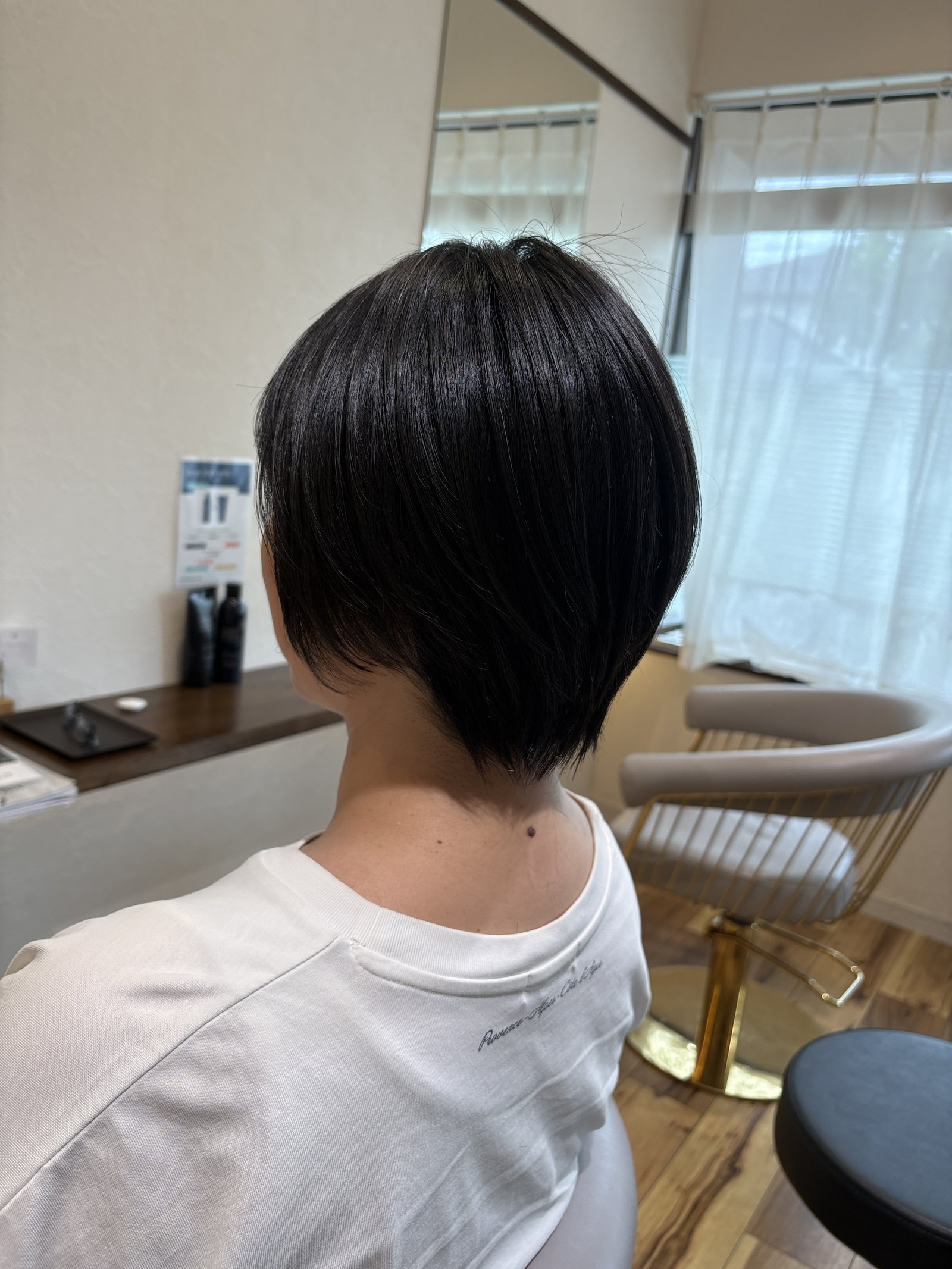 大人のナチュラルショート|後頭部からえり足へ丸くつながるシルエットと、表面のなめらかなツヤ・右からの斜め後ろ