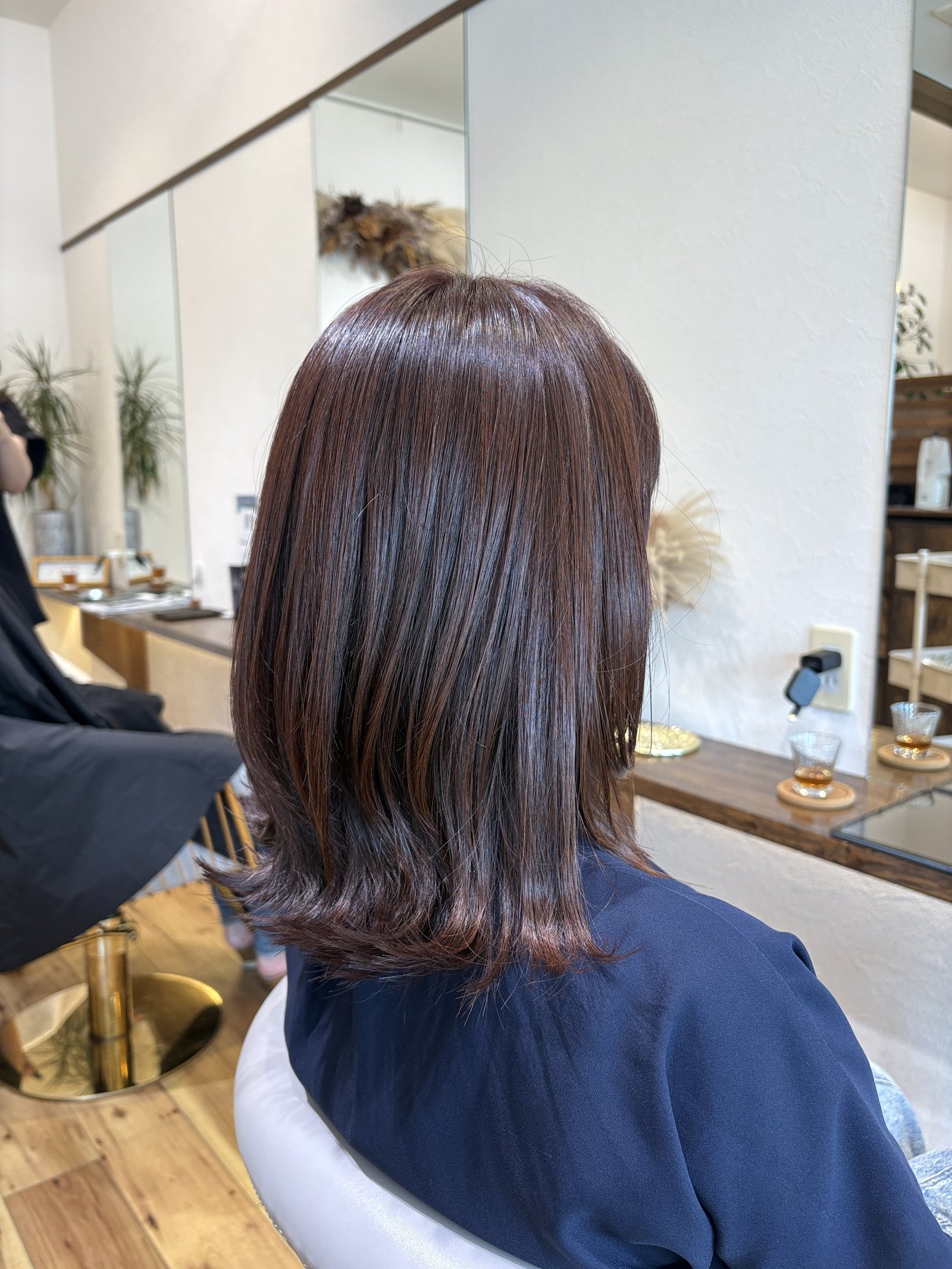 くびれ外ハネミディアム×秋色ピンクベージュ|毛先に入れた段でできるくびれと、外へ軽く流れる毛先を反対側の斜め後ろから