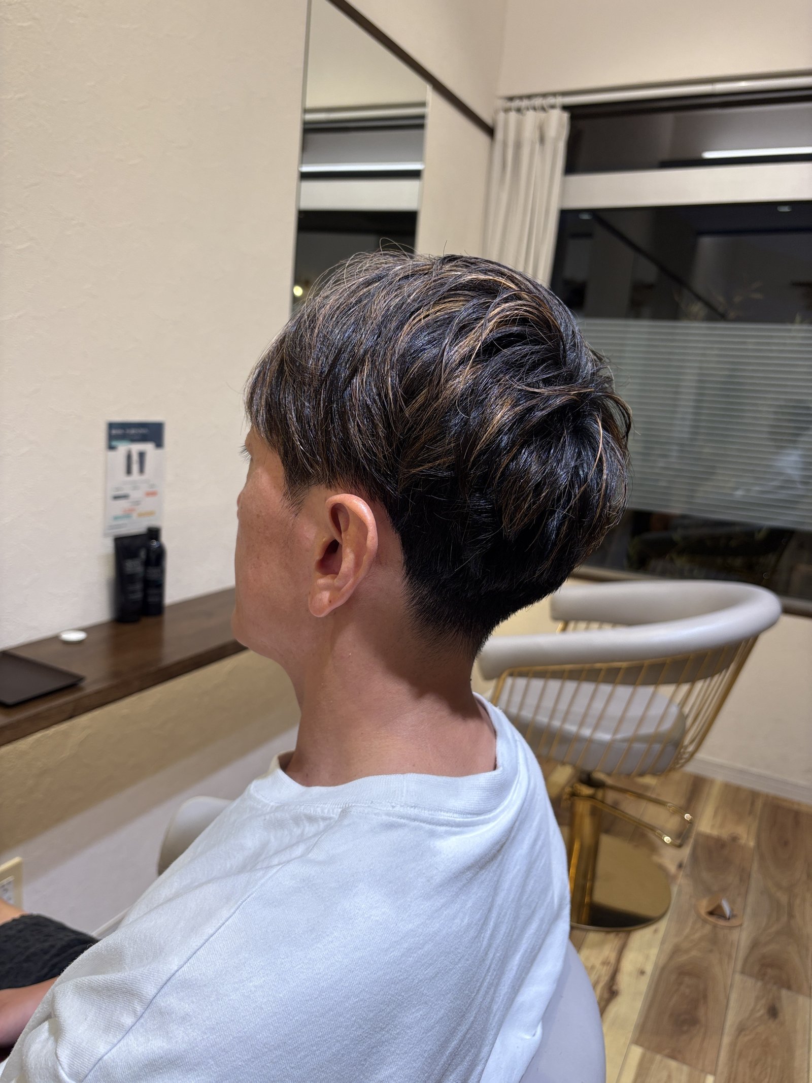 ブルーブラック×パープルハイライトのメンズショート｜光の当たり方でうっすらパープルがのぞく表面と、短めのえり足／左斜め後ろから