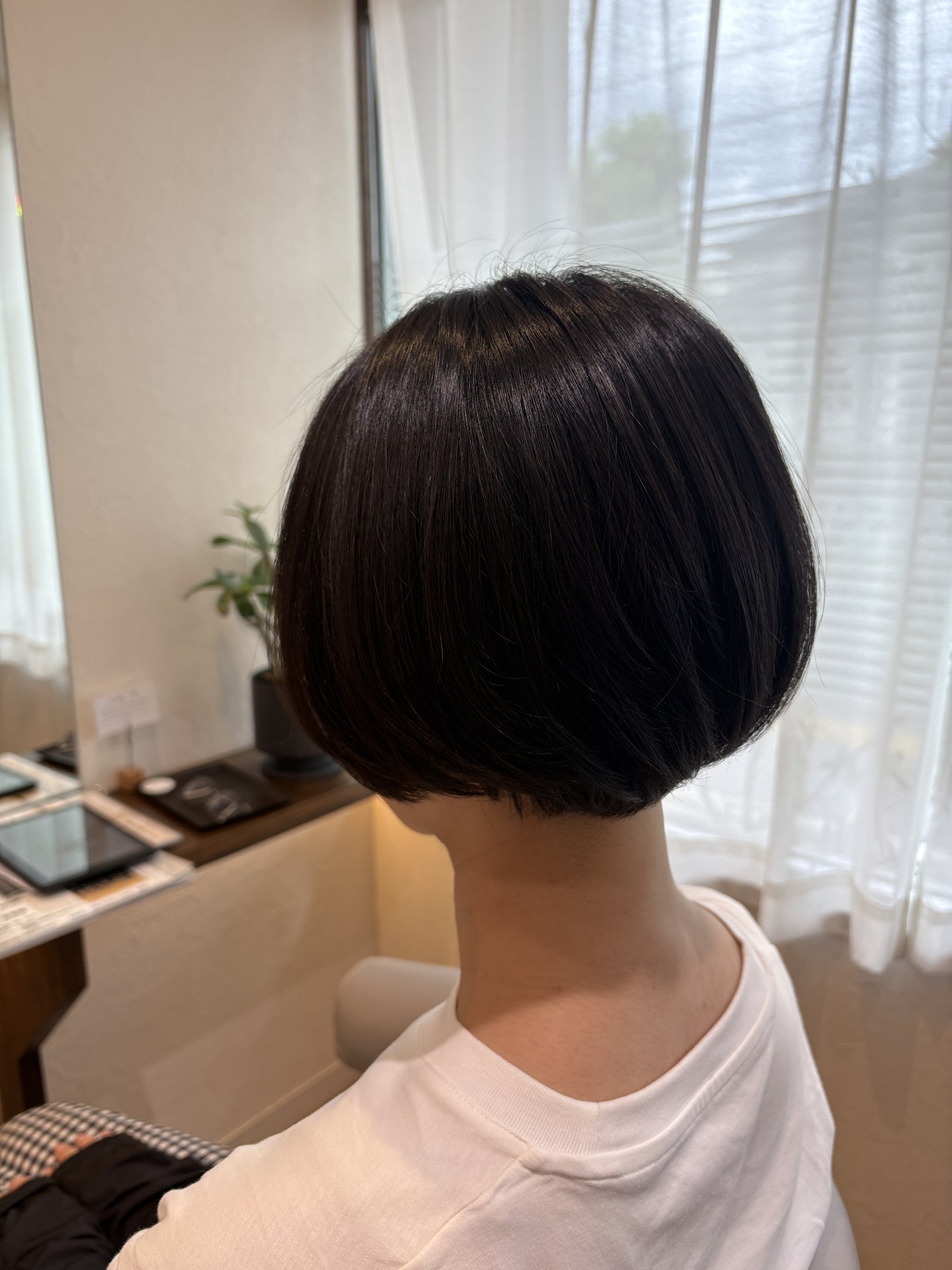 大人の丸みショートボブ｜首すじに沿って丸く収まる毛先と、なめらかに光る表面／右斜め後ろから